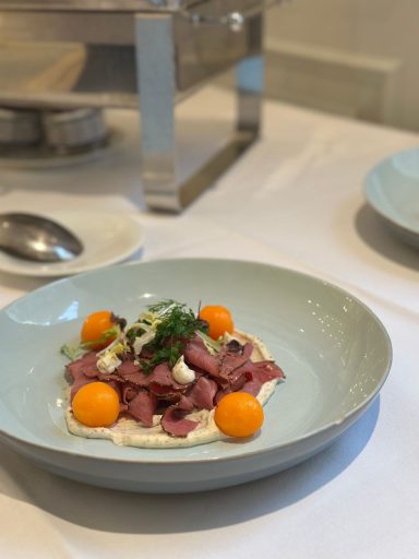 Lunch-Variation Gericht mit dünn geschnittenem Fleisch, Melonenbällchen und einer cremigen Sauce.
