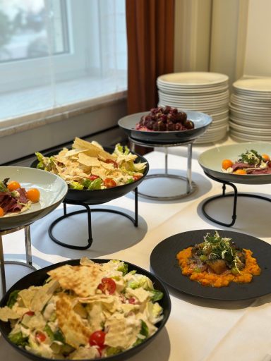 Lunch-Menü Vielfältige Salate und kleine Gerichte auf stilvollen Tellern, serviert auf Tischen.